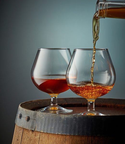 two glasses of cognac on old wooden barrel